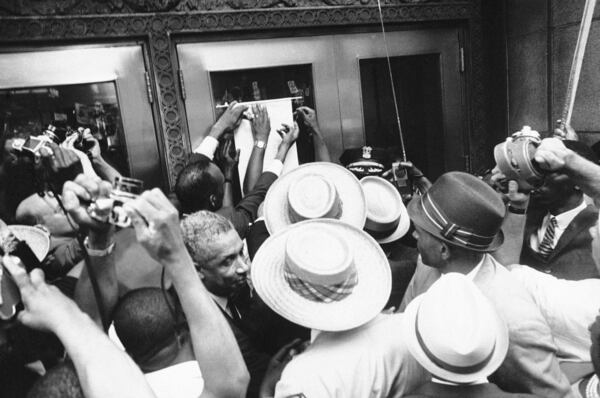 FILE - Hands of civil rights leaders Al Raby, left, and Dr. Martin Luther King, post a scroll on door of Chicago's City Hall, July 10, 1966. (AP Photo/Larry Stoddard, File)