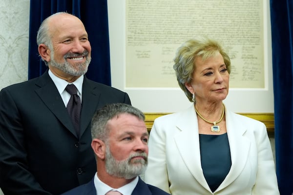 Commerce Secretary Howard Lutnick and Education Secretary Linda McMahon watch as President Donald Trump speaks with reporters in the Oval Office of the White House, Wednesday, April 23, 2025, in Washington. (AP Photo/Alex Brandon)