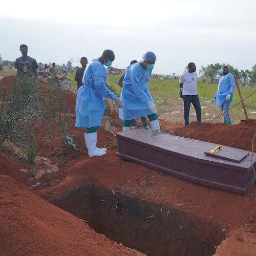 FILE - People dressed in protective gear prepare to lower into a grave the coffin containing the remains of six-year-old Baudjo Baraka Jules, who died of Ebola, in Bunia, Ituri province, eastern Congo, on Aug. 18, 2026. (AP Photo/Dieudonne Dirole, File)