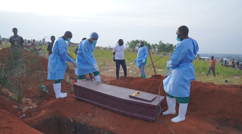 FILE - People dressed in protective gear prepare to lower into a grave the coffin containing the remains of six-year-old Baudjo Baraka Jules, who died of Ebola, in Bunia, Ituri province, eastern Congo, on Aug. 18, 2026. (AP Photo/Dieudonne Dirole, File)
