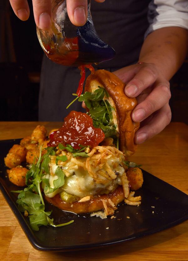 A Death by Peaches Burger is topped with Peach Pepper Jam at Stage Kitchen & Bar. (Styling by chef Vereak Chum / Chris Hunt for the AJC)
