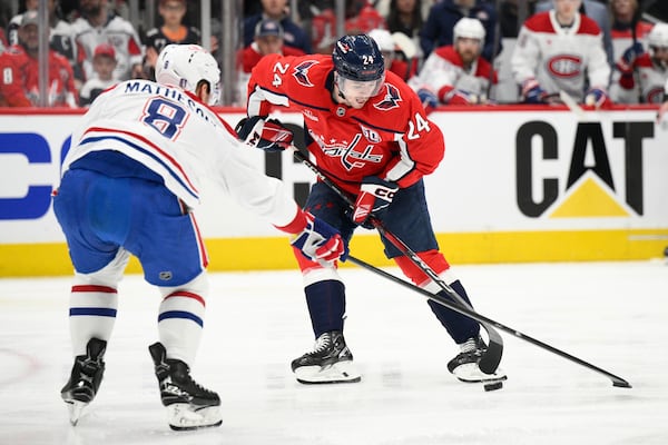 Washington Capitals center Connor McMichael (24) and Montreal Canadiens defenseman Mike Matheson (8) battle for the puck in the first period of Game 1 of a first-round NHL hockey playoff series Monday, April 21, 2025, in Washington. (AP Photo/Nick Wass)