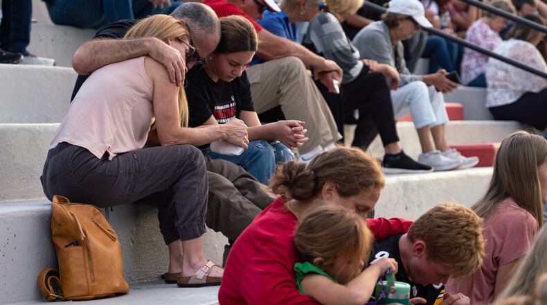 Families bow their heads in prayer on Sept. 8 at a gathering at Flowery Branch High School to celebrate the life of Ricky Aspinwall II, killed in a shooting at Apalachee High School in Winder, Georgia. (Ben Hendren for The Atlanta Journal-Constitution)