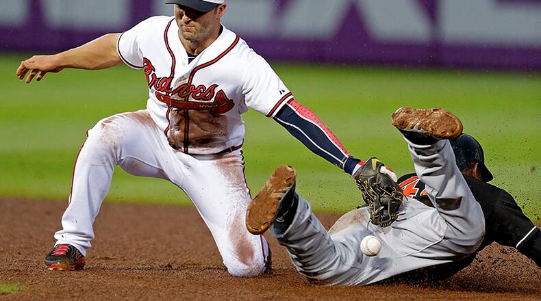 Braves second baseman Dan Uggla loses the ball as he attempts to tag out Miami Marlins' Marcell Ozuna on a steal at second base in the fourth inning. The Braves lost 4-3.