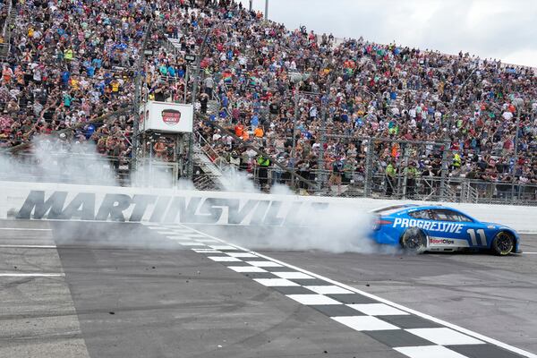 Denny Hamlin (11) perform a burnout after winning a NASCAR Cup Series auto race in Martinsville, Va., Sunday, March 30, 2025. (AP Photo/Chuck Burton)