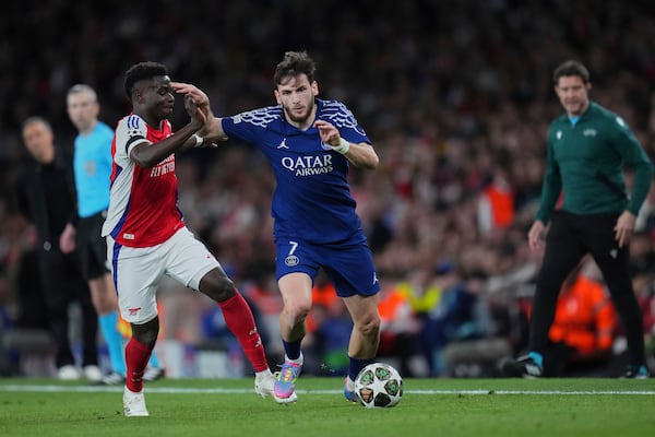 Arsenal's Bukayo Saka, left, fights for the ball with PSG's Khvicha Kvaratskhelia during the Champions League semifinal first leg soccer match between Arsenal and Paris Saint-Germain at Emirates Stadium in London, England, Tuesday, April 29, 2025. (AP Photo/Kirsty Wigglesworth)