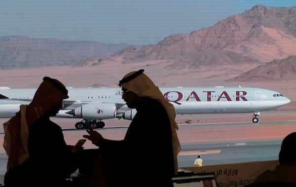 FILE - Journalists chat as video of a plane is shown on a screen while landing at at Al Ula airport in Saudi Arabia, Jan. 5, 2021. (AP Photo/Amr Nabil, file)