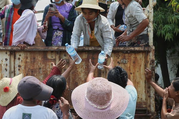 In this photo released by Xinhua News Agency, volunteers distribute water to people affected by the earthquake in Sagaing, Myanmar, Tuesday, April 1, 2025. (Myo Kyaw Soe/Xinhua via AP)
