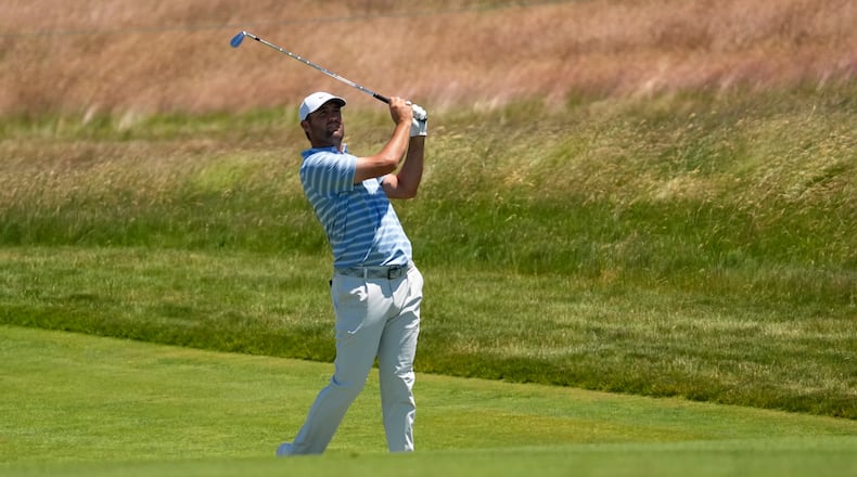 Scottie Scheffler watches his shot on the 13th hole during a practice round for the U.S. Open golf tournament at Shinnecock Hills Golf Club in Southampton, N.Y., Monday, June 15, 2026.(AP Photo/David J. Phillip)