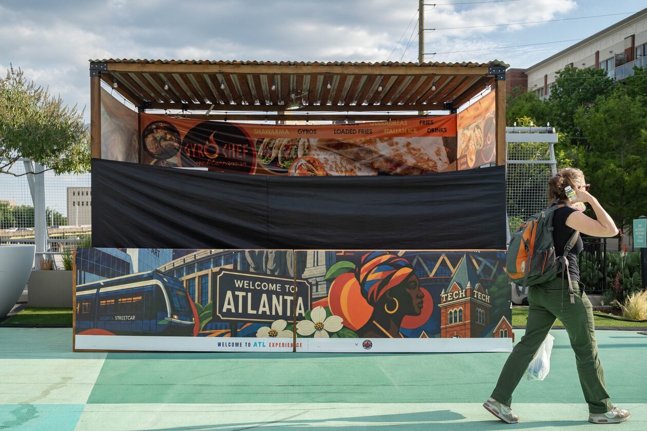 A shuttered Gyro Chef Mediterranean booth sits empty as a pedestrian passes by on the Steele Bridge in downtown Atlanta on June 24, 2026. (Ben Hendren for the AJC)