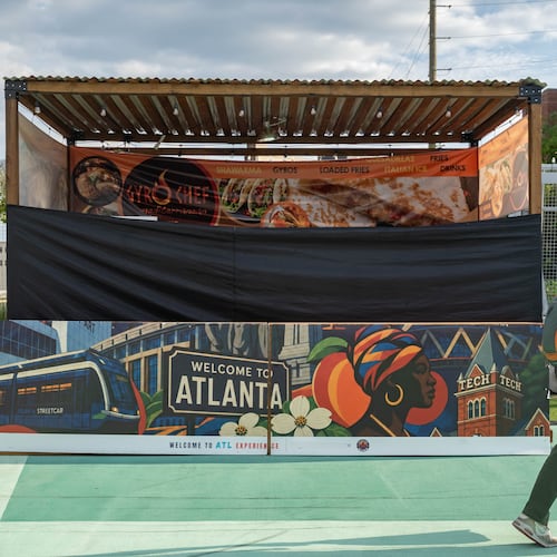 A shuttered Gyro Chef Mediterranean booth sits empty as a pedestrian passes by on the Steele Bridge in downtown Atlanta on June 24, 2026. (Ben Hendren for the AJC)