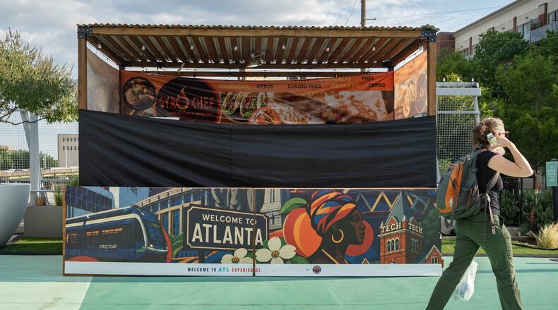 A shuttered Gyro Chef Mediterranean booth sits empty as a pedestrian passes by on the Steele Bridge in downtown Atlanta on June 24, 2026. (Ben Hendren for the AJC)