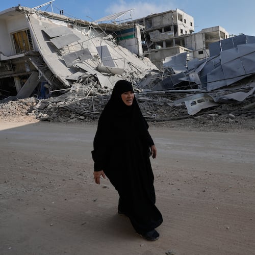 A woman returns to her village following the announcement of an initial ceasefire agreement between the United States and Iran, walks at her destroyed neighbourhood in Nabatiyeh town, southern Lebanon, Tuesday, June 16, 2026. (AP Photo/Hussein Malla)