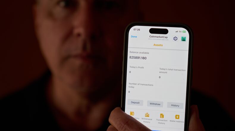Chris Colocousis holds up a screenshot of the fake app where he invested his savings showing his account had more than doubled to nearly $826,000 as part of a scam in which he says he lost $400,000 at his home in Raynham, Mass., Tuesday, March 10, 2026. (AP Photo/David Goldman)