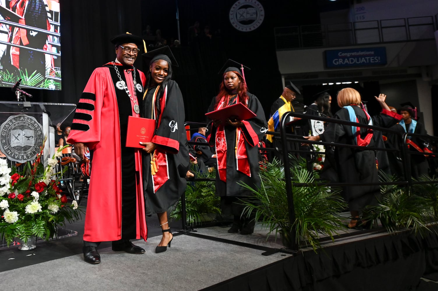 Clark Atlanta University President George T. French Jr. takes photos with students as the cross the stage during the university’s 2025 commencement ceremony Sunday, May 18, 2025 at Georgia State’s Convocation Center. (Daniel Varnado/For the Atlanta Journal-Constitution)