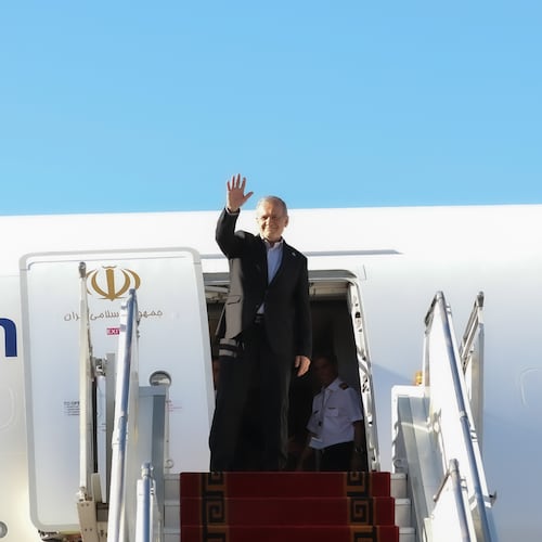 In this photo released by the Iranian Presidency Office, President Masoud Pezeshkian waves to media and officials as he boards his plane while leaving Mehrabad airport for New York to attend the UN General Assembly, in Tehran, Iran, Tuesday, Sept. 22, 2026. (Iranian Presidency Office via AP)