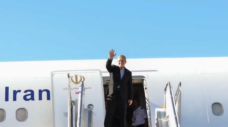In this photo released by the Iranian Presidency Office, President Masoud Pezeshkian waves to media and officials as he boards his plane while leaving Mehrabad airport for New York to attend the UN General Assembly, in Tehran, Iran, Tuesday, Sept. 22, 2026. (Iranian Presidency Office via AP)