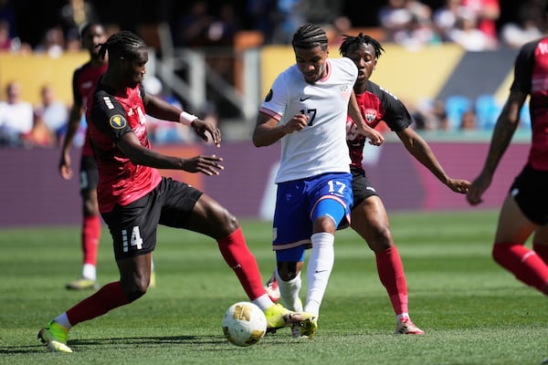 United States forward Malik Tillman (17) brings the ball up the field between Trinidad and Tobago defender Sheldon Bateau, left, and midfielder Ajani Fortune during the second half of a CONCACAF Gold Cup soccer match in San Jose, Calif., Sunday, June 15, 2025. (AP Photo/Jeff Chiu)