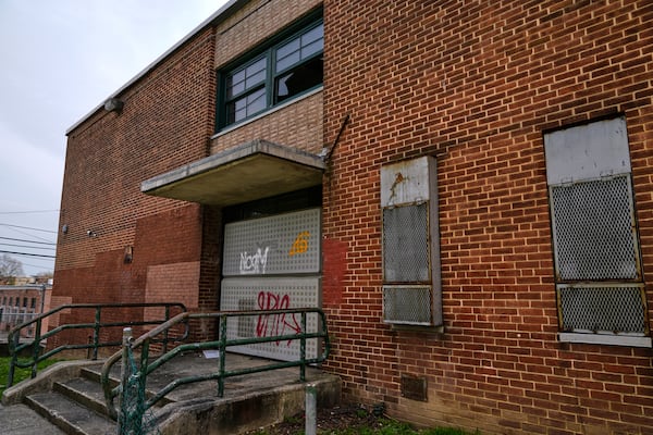 A side entrance of the vacant Lillian S. Jones Recreation Center is boarded shut and a broken window is seen, Monday, April 14, 2025, in the Sandtown-Winchester neighborhood in Baltimore. (AP Photo/Stephanie Scarbrough)