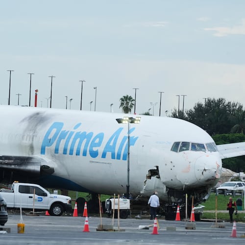 Workers inspect an Amazon cargo plane that overshot a runway four days ago at Miami International Airport, Thursday, Sept. 10, 2026, in Miami. (AP Photo/Marta Lavandier)