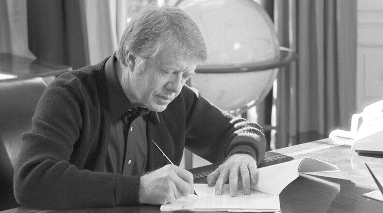 President Carter works at his desk in the Oval Office on February 8, 1977. (Jimmy Carter Library)