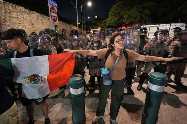 Anti ICE protesters gather near the Alamo as Texas state troopers keep watch in downtown San Antonio, Wednesday, June 11, 2025. (AP Photo/Eric Gay)