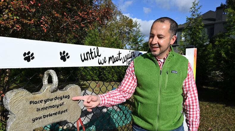 Dr. Humberto Fallas with dogtags, other pet owners have hung, at a memorial of his German shepherd, Ace, near his office Fallas Family Vision in McDonough.(Hyosub Shin / Hyosub.Shin@ajc.com)