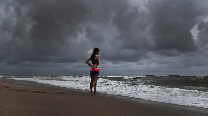 Alicia Herrera, 10, visiting from Germany doesn’t let dark clouds ruin her day at beach Friday, May 25, 2018 in Fort Lauderdale, Fla. A flood watch is expected for South Florida on Saturday morning as a result of Subtropical Storm Alberto. (Carline Jean/Sun Sentinel/TNS)