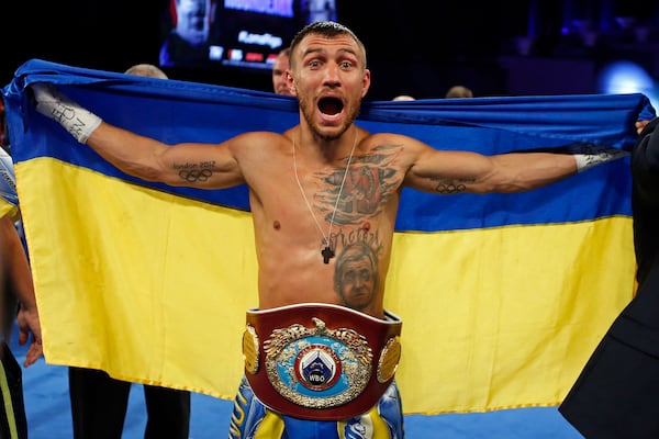 FILE - Vasiliy Lomachenko, of Ukraine, celebrates after defeating Guillermo Rigondeaux in a WBO junior lightweight title boxing match in New York, Dec. 9, 2017. (AP Photo/Adam Hunger, File)