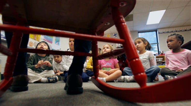Kindergarten students in Norcross listen to a parent volunteer read the children's book "Corduroy." How kids learn to read has been an ongoing debate. A former education reporter talks about how she failed to drill down into the essence of that debate over how best to get kids reading. (AJC file photo)
