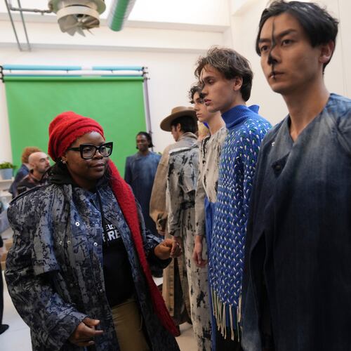 Afro Fashion Association founder Michelle Ngonmo prepares models in the backstage of the Victor-Hart Fall/Winter 2026-2027 Men's fashion show presented in Milan, Italy, Jan. 18, 2026. (AP Photo/Antonio Calanni)