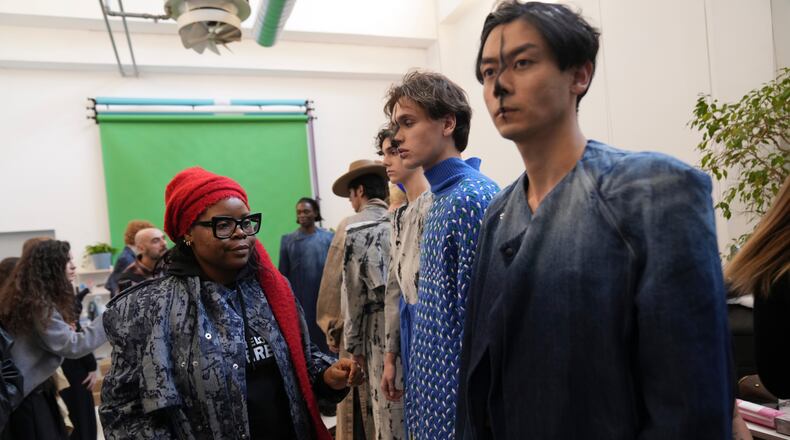 Afro Fashion Association founder Michelle Ngonmo prepares models in the backstage of the Victor-Hart Fall/Winter 2026-2027 Men's fashion show presented in Milan, Italy, Jan. 18, 2026. (AP Photo/Antonio Calanni)