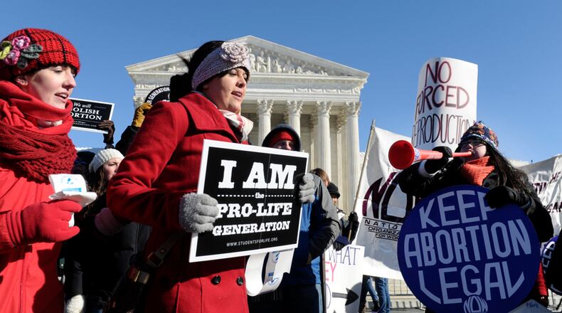 ABORTION RULING ANNIVERSARY--Pro-abortion and anti-abortion protestors rally outside the Supreme Court in Washington, Wednesday, Jan. 22, 2014. Thousands of abortion opponents are facing wind chills in the single digits to rally and march on Capitol Hill to protest legalized abortion, with a signal of support from Pope Francis. (AP Photo/Susan Walsh)