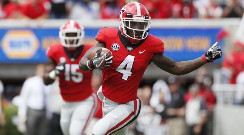 Georgia’s Mecole Hardman (4) returns a first-half punt for a touchdown Saturday against Middle Tennessee at Sanford Stadium. Bob Andres/bandres@ajc.com
