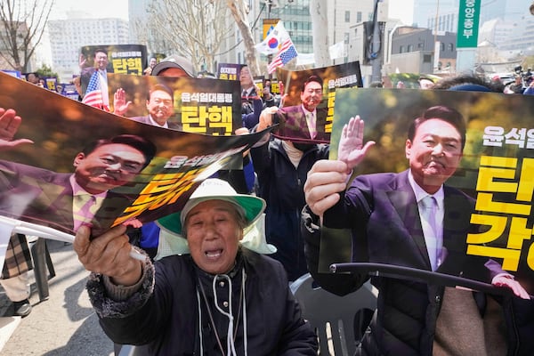 Supporters of impeached South Korean President Yoon Suk Yeol attend a rally to oppose his impeachment near the Constitutional Court in Seoul, South Korea, Tuesday, April 1, 2025. The letters read " Dismiss impeachment." (AP Photo/Ahn Young-joon)