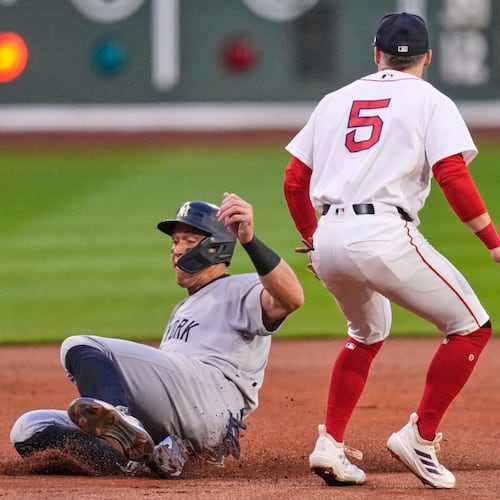 New York Yankees' Aaron Judge, left, beats the throw to Boston Red Sox third baseman Caleb Durbin (5) while advancing on a double by Giancarlo Stanton during the first inning during of a baseball game at Fenway Park, Wednesday, April 22, 2026, in Boston. (AP Photo/Charles Krupa)