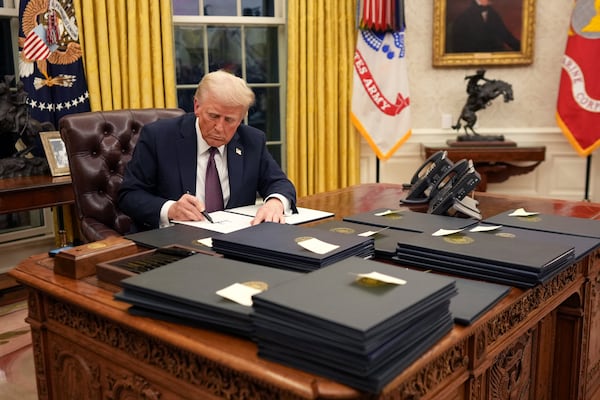 President Donald Trump signs executive orders in the Oval Office of the White House in Washington on Monday, Jan. 20, 2025, following his inauguration as the 47th president. President Trump made major policy moves immediately after taking office, withdrawing from major international agreements, promising steep tariffs and pardoning nearly all of the Jan. 6 rioters. (Doug Mills/The New York Times)
                      
