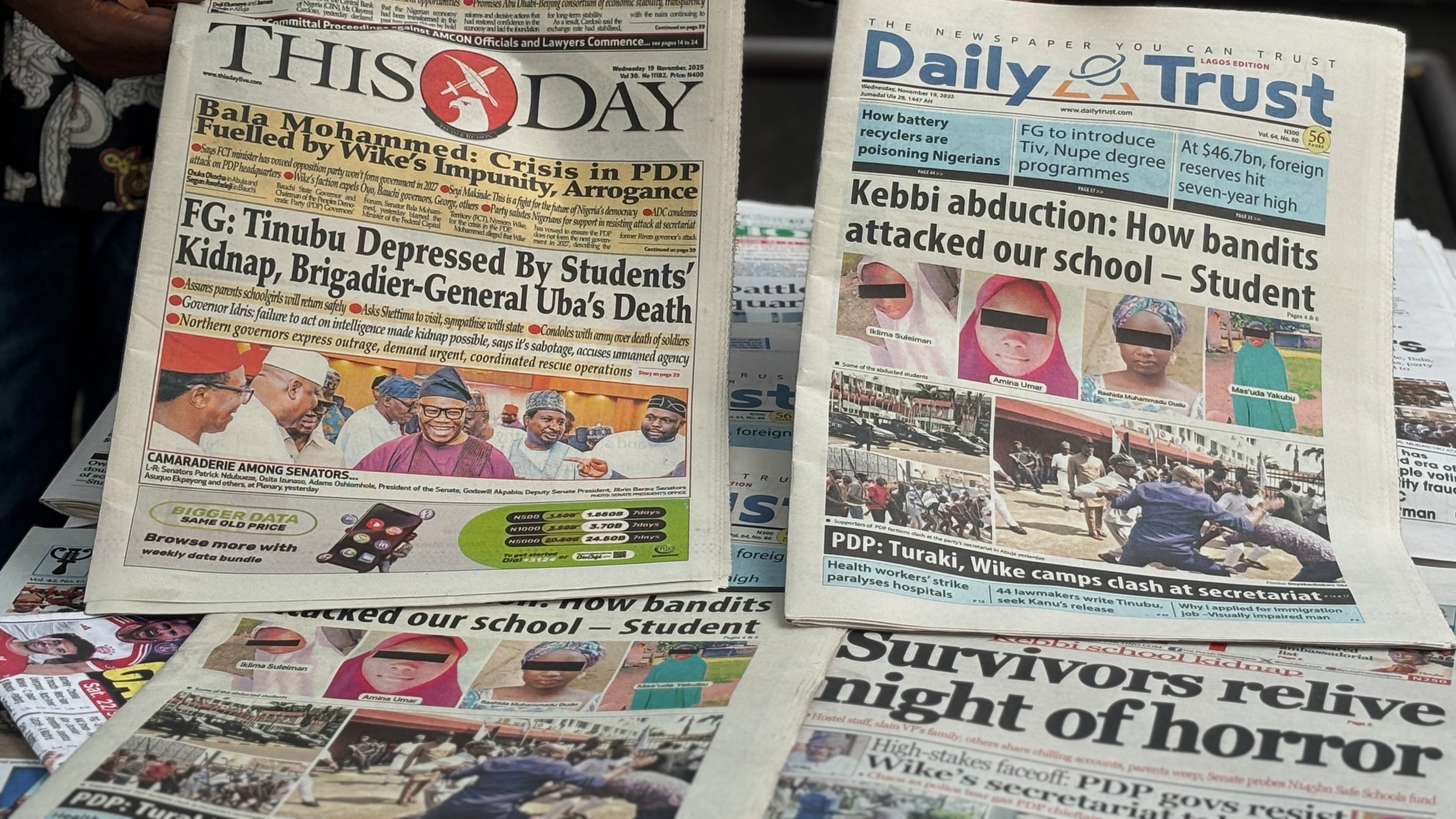 A vendor display local newspapers on the street of Lagos with headlines of the Government Girls Comprehensive Secondary School, where gunmen on Monday attacked the school dormitory, abducted schoolgirls, in Kebbi Nigeria, Wednesday, Nov. 19 2025. (AP Photo/Sunday Alamba )