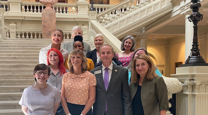 State Rep. Bill Werkheiser (front) stands with supporters in the Georgia State Capitol on Tuesday after his measure aimed at keeping intellectually disabled people off death row was signed into law.