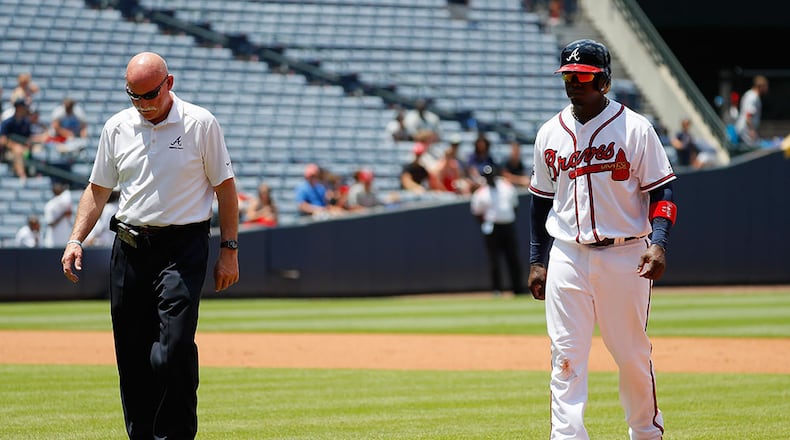 Braves third baseman Adonis Garcia is escorted off the field by trainer Jeff Porter after suffering an injury in the seventh inning against the Cincinnati Reds Thursday, June 16, 2016, at Turner Field in Atlanta.