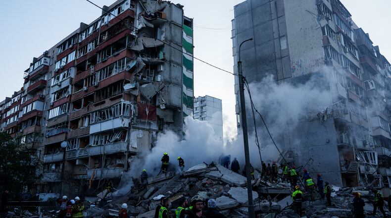 Rescue workers clear the rubble of a house heavily damaged after a Russian strike on a residential neighborhood in Kyiv, Ukraine, on Thursday, May 14, 2026. (AP Photo/Evgeniy Maloletka)