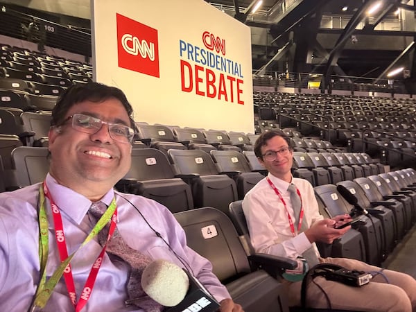 WABE politics reporters Rahul Bali, left, and Sam Gringlas pose for a photo shortly before taping an episode of their politics podcast following the 2024 presidential debate in Atlanta.