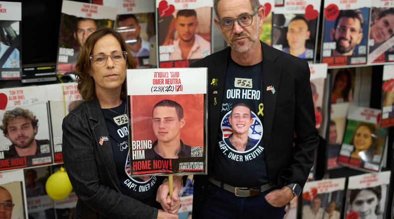 Ronen and Orna Neutra, parents of Omer Neutra, a U.S.-Israeli citizen who was killed in the Hamas-led attacks on Oct. 7, 2023, present a photo of their son in Tel Aviv, Israel, Monday, Oct. 27, 2025. (AP Photo/Ariel Schalit)