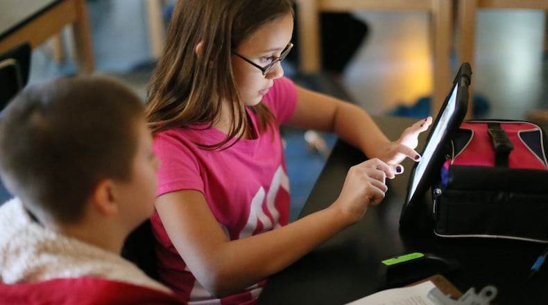 Jacob Morgan (left) and Alex Kirsche work on a collage for a science project on erosion and deposition. At Locust Grove Middle School in Henry County, middle school students choose their own options in coursework for meeting standards and move on to the next subject when they are ready. They do some of their work independently in large “flex labs,” which allow smaller than usual student-teacher ratios. BOB ANDRES / BANDRES@AJC.COM