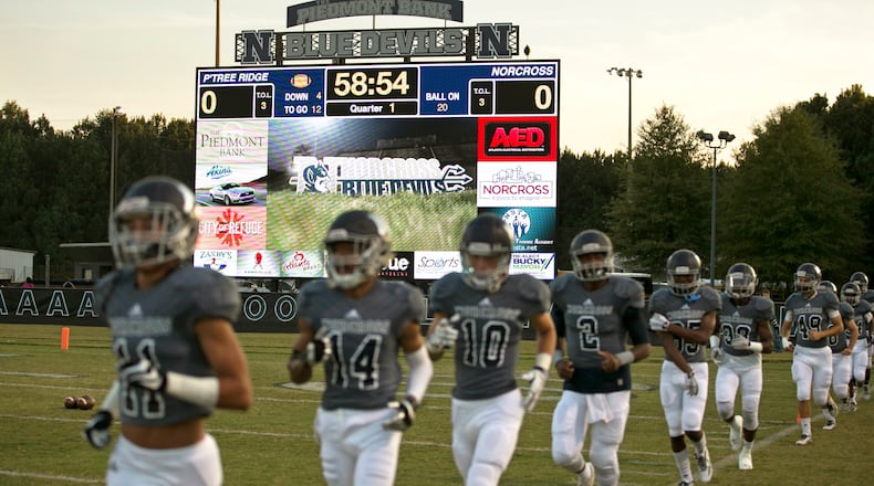 Norcross players jog onto the field in front of the school's Jumbotron before their game against Peachtree Ridge Friday at Norcross High School in Norcross, Ga., October 23, 2015. PHOTO / JASON GETZ