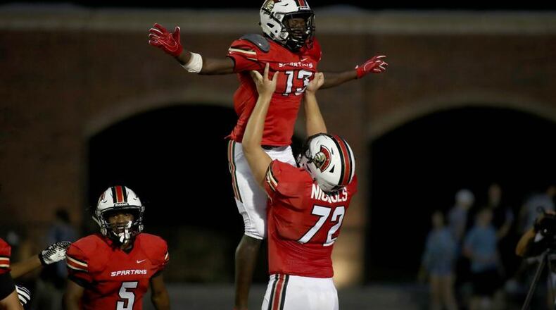 GAC wide receiver Ty James (13) celebrates a touchdown reception with offensive lineman Addison Nichols (72) in the first half of their game against Westminster at Greater Atlanta Christian Friday, August 24, 2018, in Norcross, Ga. PHOTO / JASON GETZ