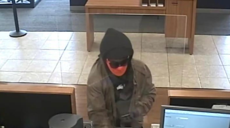 Police say a man whose face was concealed with a mask and sunglasses showed a Stockbridge bank teller his gun then handed her a robbery note and a withdrawal slip with $50,000 written on it Saturday.
