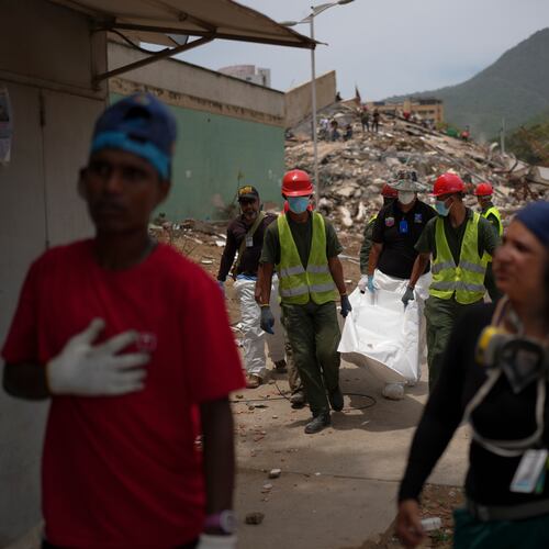 Rescue workers and forensic technician Joel Mirabal, back left, recover the body of an earthquake victim in La Guaira, Venezuela, Tuesday, June 30, 2026. (AP Photo/Matias Delacroix)
