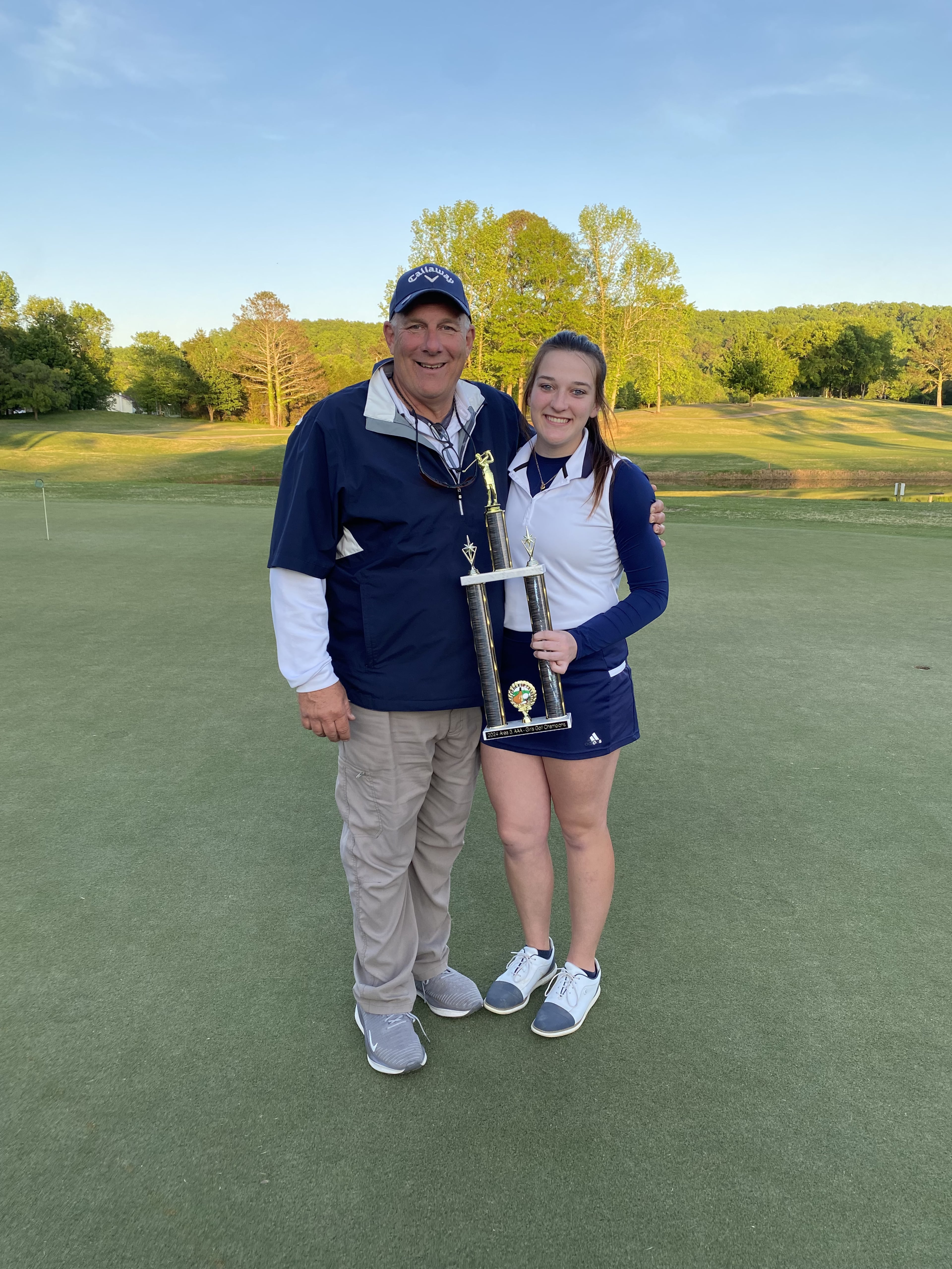 Charlsie McElhaney and her father Kevin pose with the 2024 GHSA Area 3-AAA girls golf championship trophy, won by Gordon Lee High. Charlsie’s team won this year’s GHSA Class A Division I state championship. (Courtesy McElhaney family)