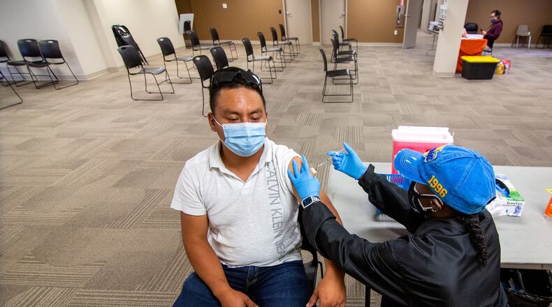 Nurse Lydia Shakespeare-Edwards gives Oscar Chavero his COVID-19 vaccination at the Mexican Consulate in Atlanta on July 16, 2021. (Steve Schaefer for The Atlanta Journal-Constitution)
